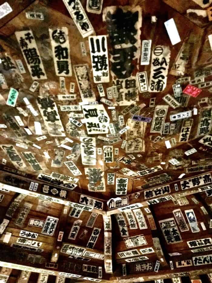 Senjafuda stickers cover the ceiling of Sazaedō shrine.