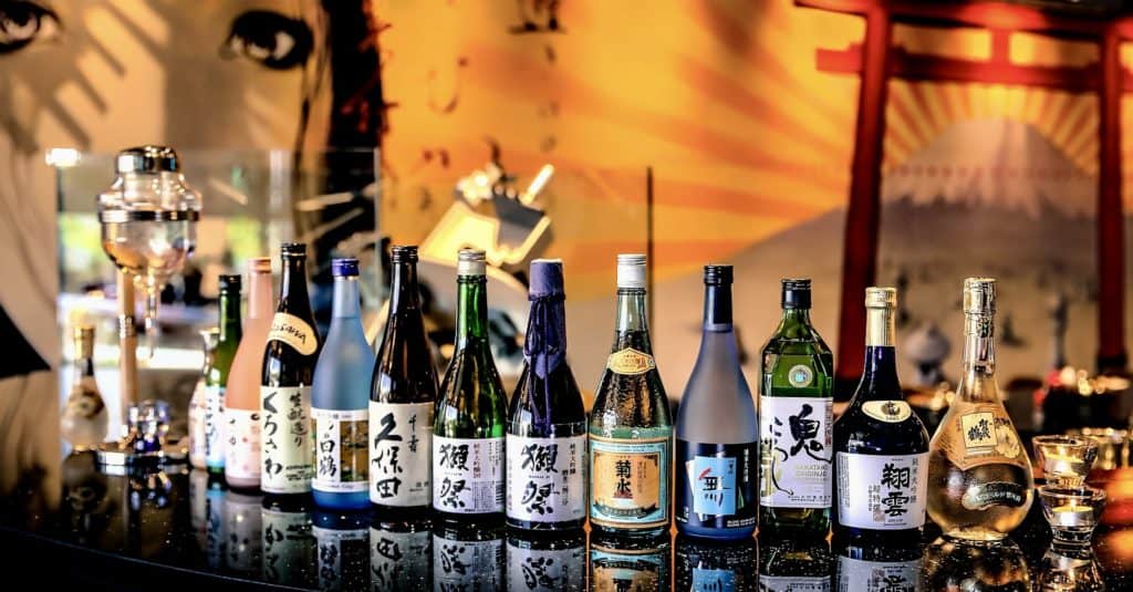 Sake bottles lined on a bar.