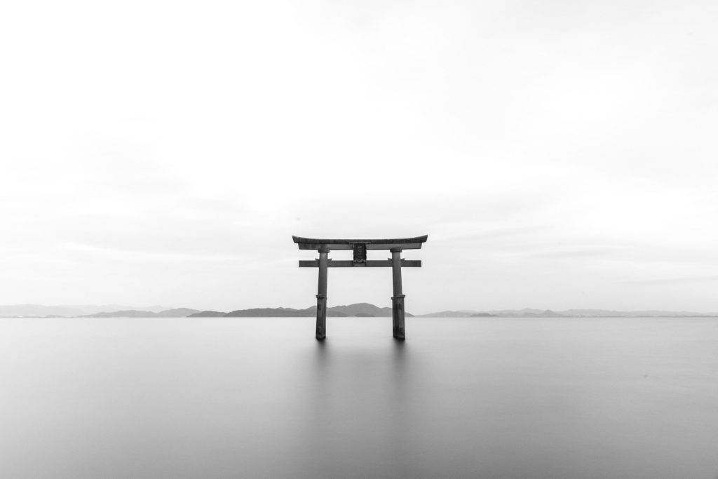 Shinto torii gate towers above the misty waters of Lake Biwa.