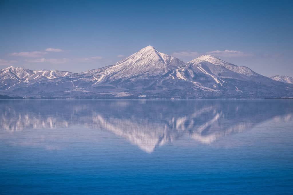 Snow-capped Mount Bandai is reflected in the still waters of Lake Inawashiro, Fukushima.