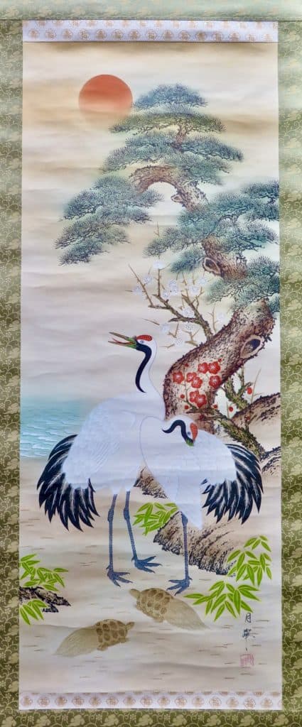 Turtles, cranes, and a pine tree adorn a hanging scroll.