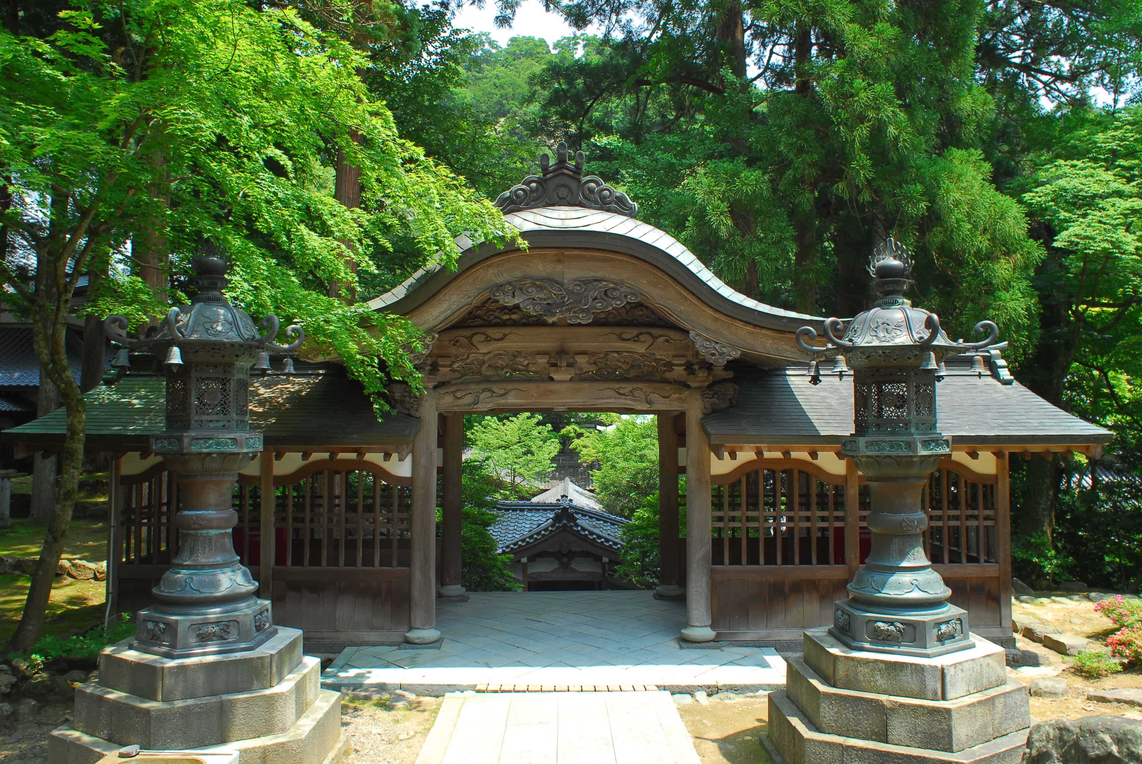 Buddhist temple gate amid lush greenery.