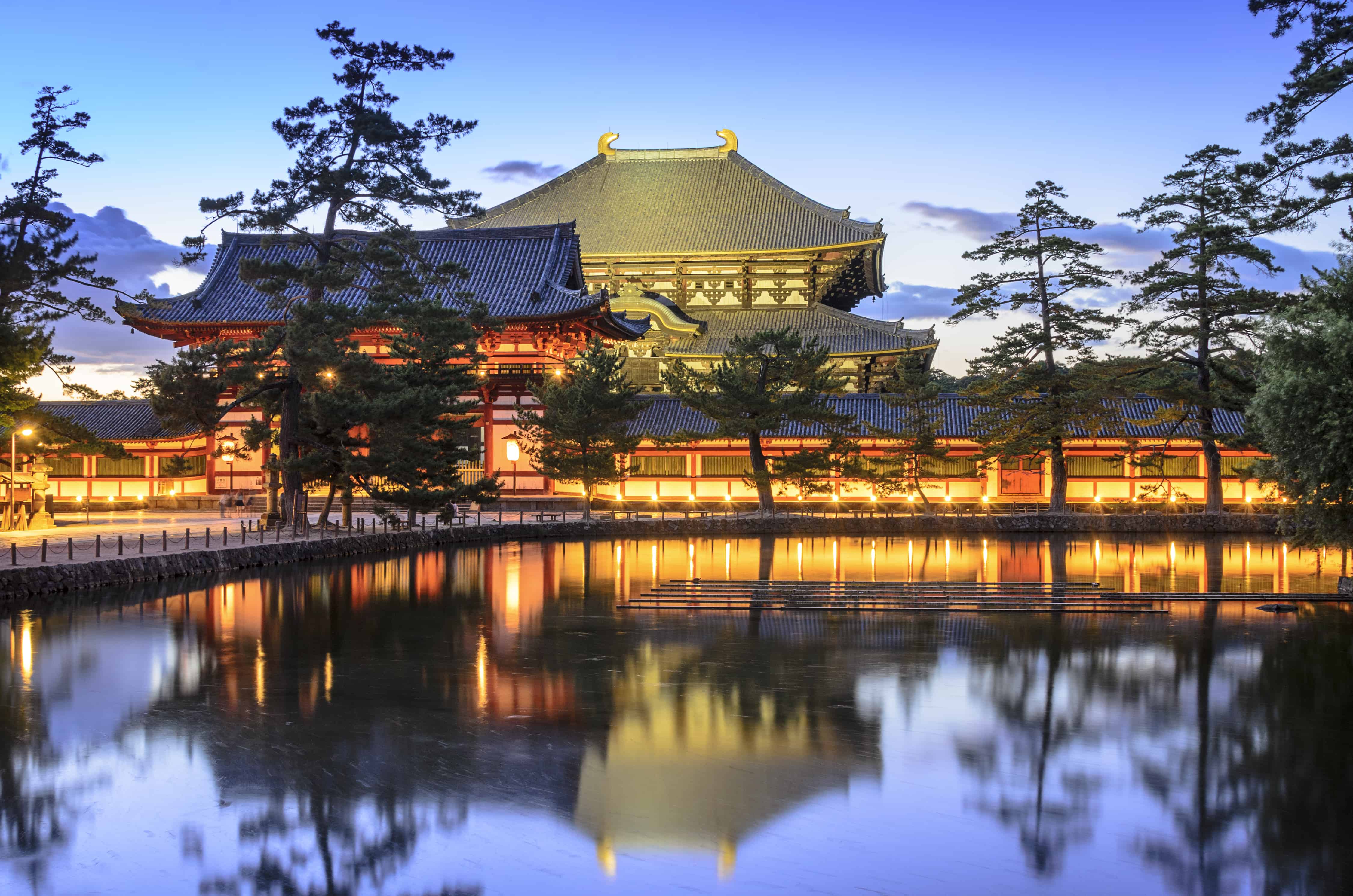 Buddhist Todaiji temple with golden light reflecting in a pond.