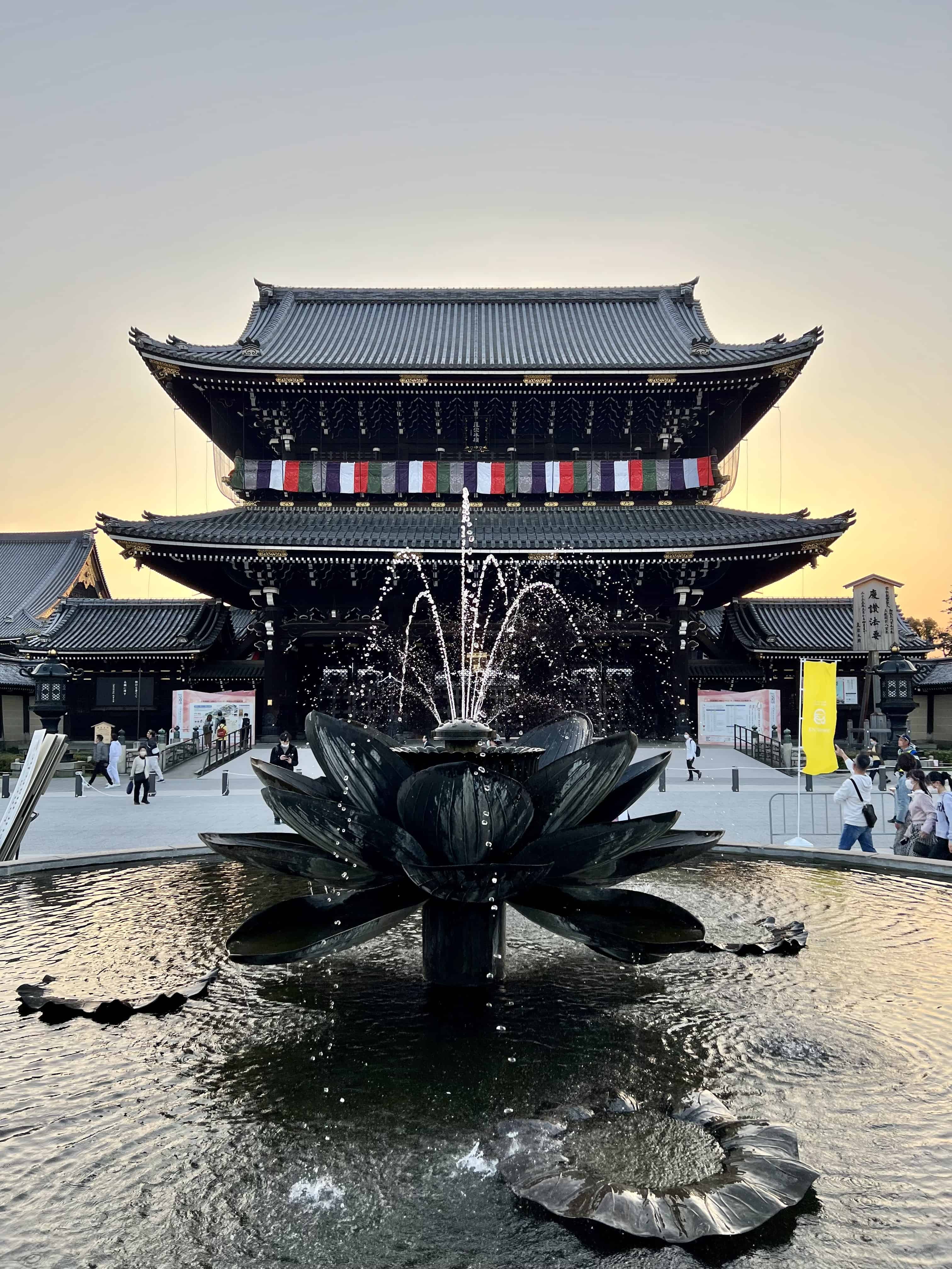 Temple gate fronted by a fountain at sunset.