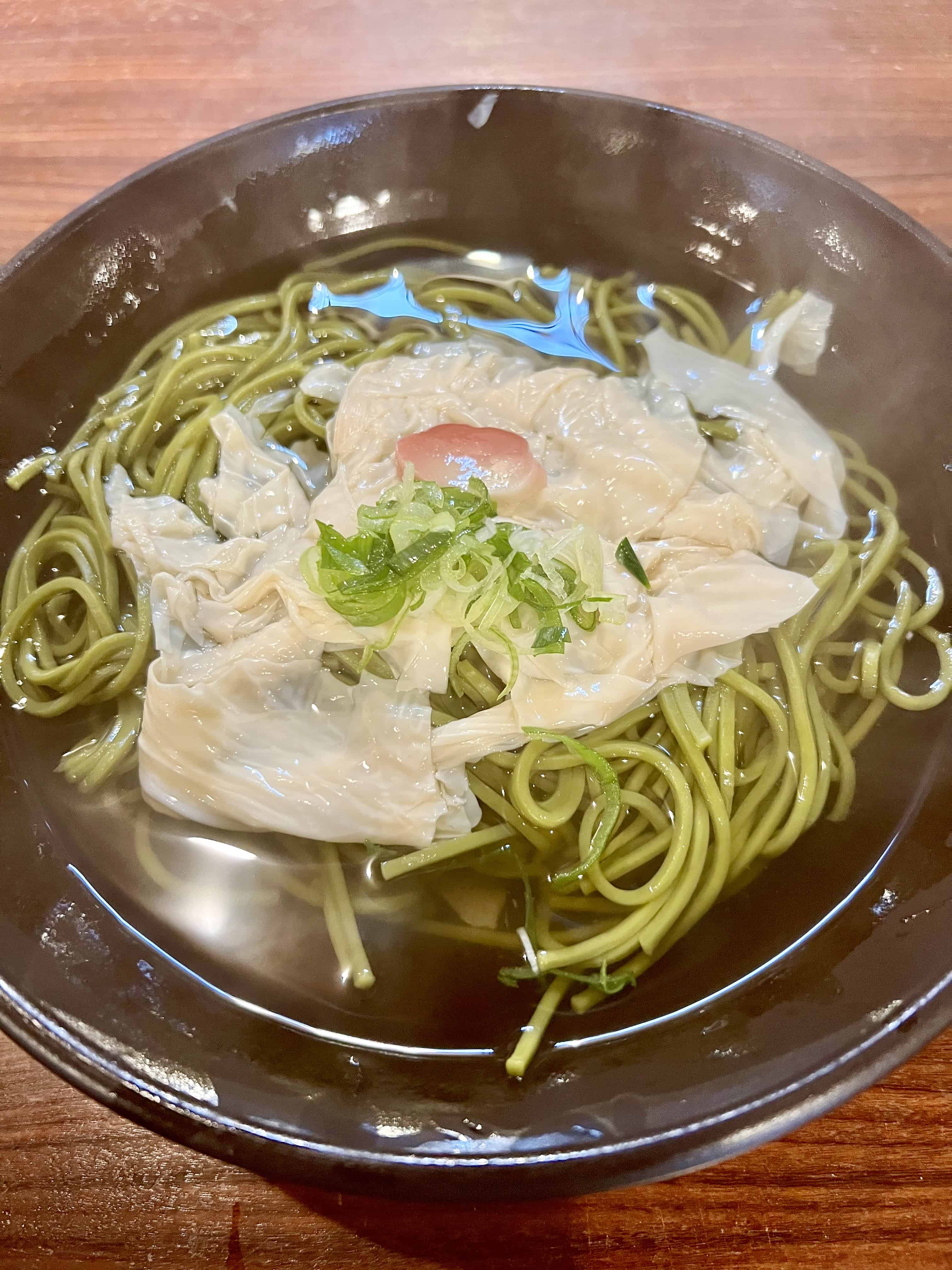 Green matcha soba noodles topped with white, filmy yuba.
