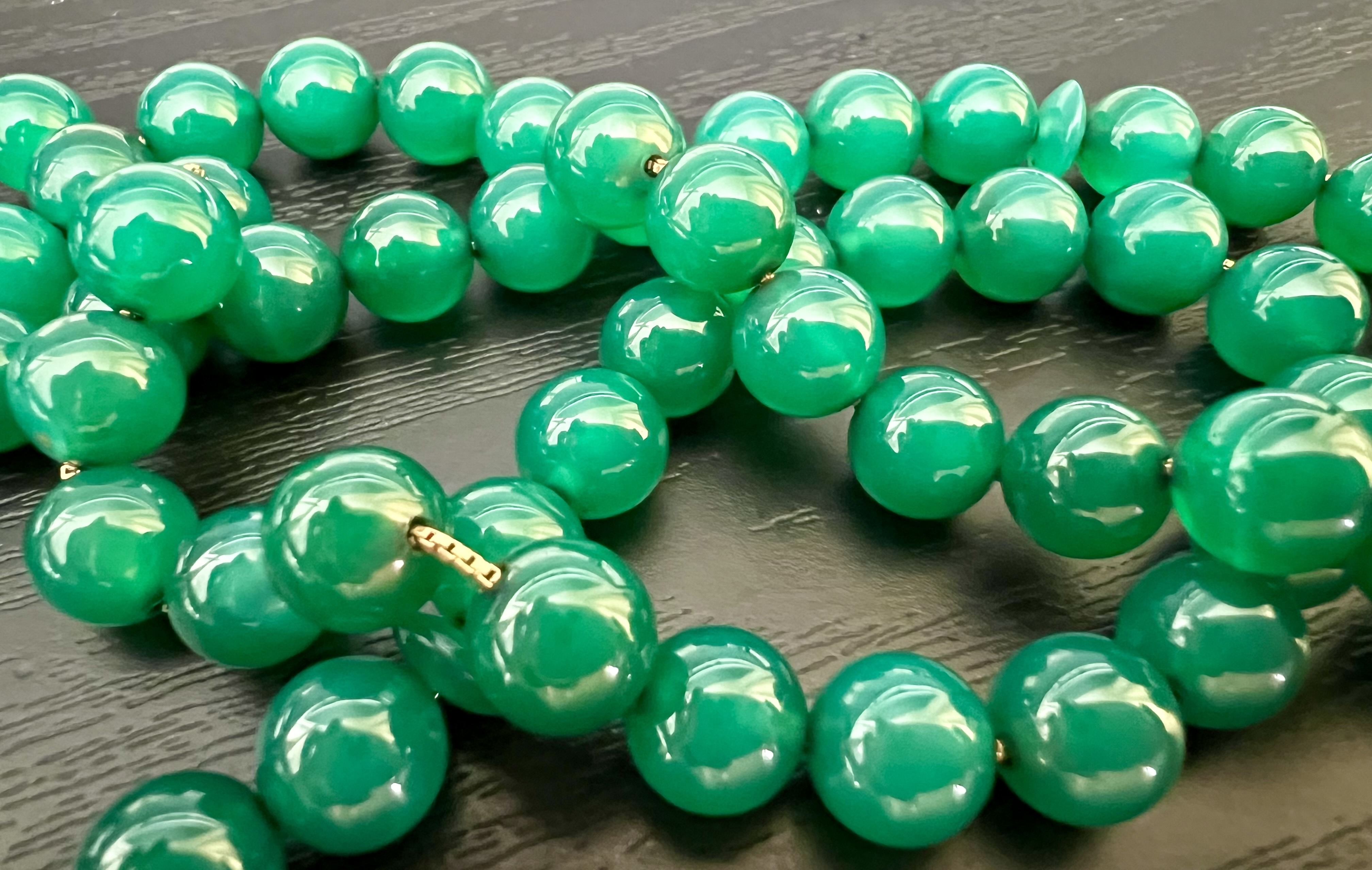 A glistening string of jade beads on gold chain.