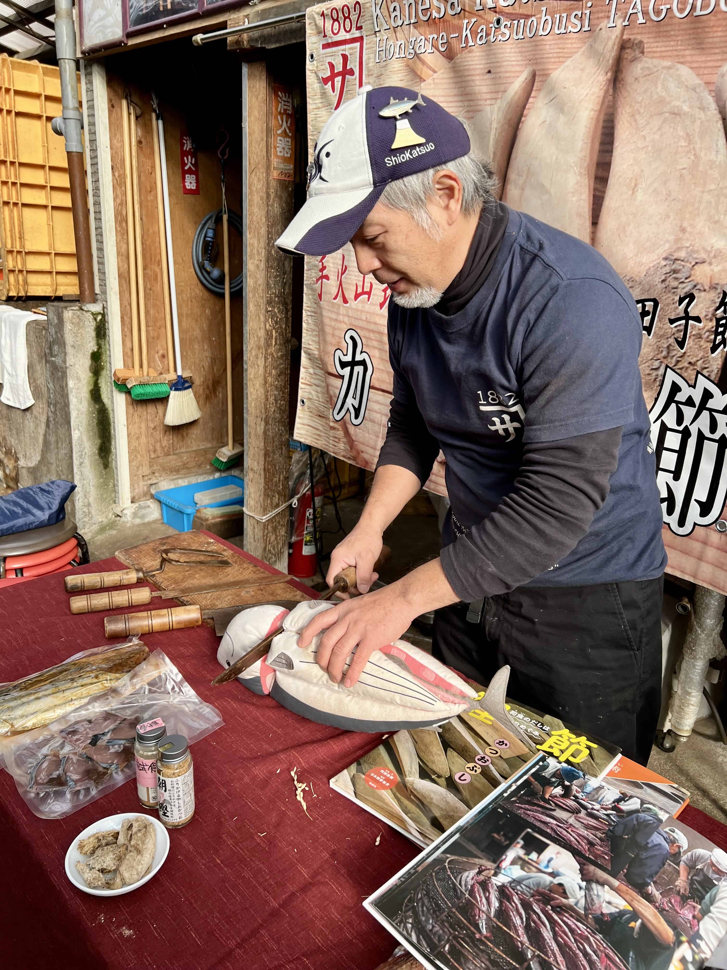 Demonstrating how a bonito is filleted by using a child's toy with separable parts.