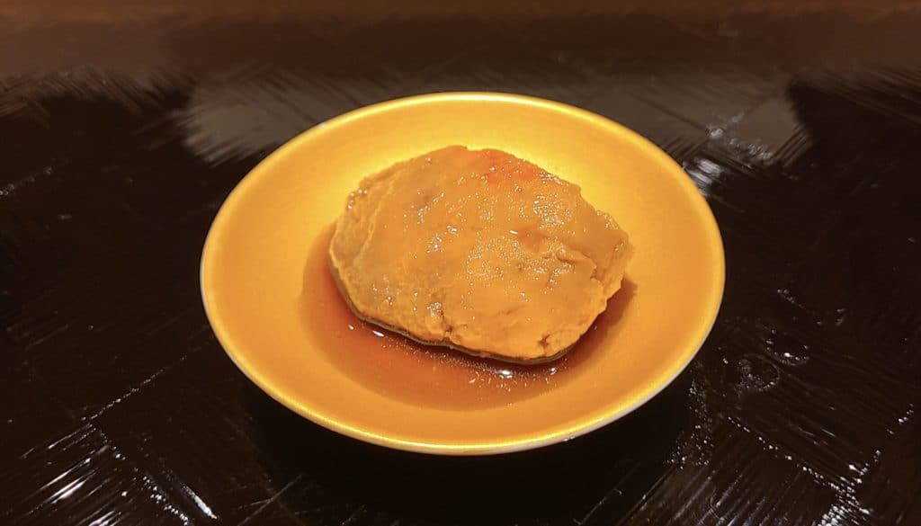 Orange roll-shaped liver covered in a light sauce.