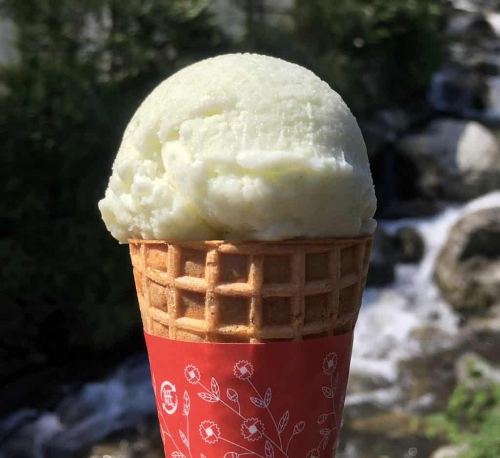 Pale green ice cream atop a wafer cone.