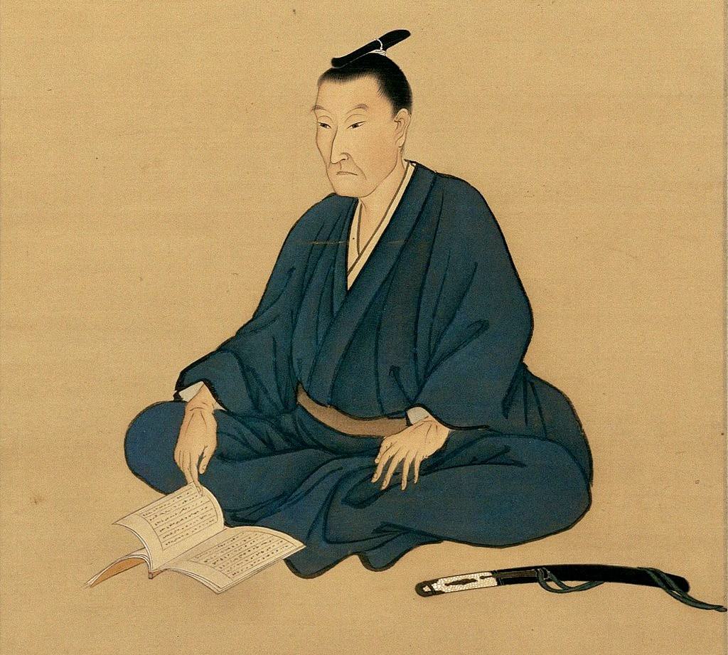 Yoshida Shoin sitting with a book.