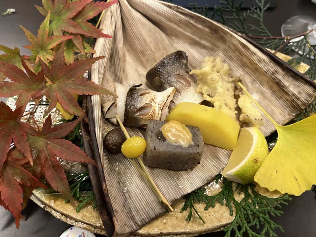 Konnyaku served alongside fish, ginkgo nut, and other autumnal foods.